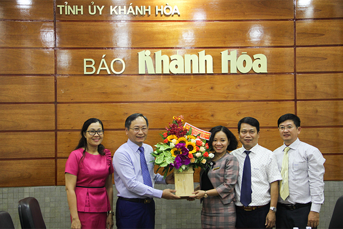 Ông Nguyễn Đắc Tài (thứ 2 từ phải qua) tặng hoa chúc mừng Báo Khánh Hòa. 