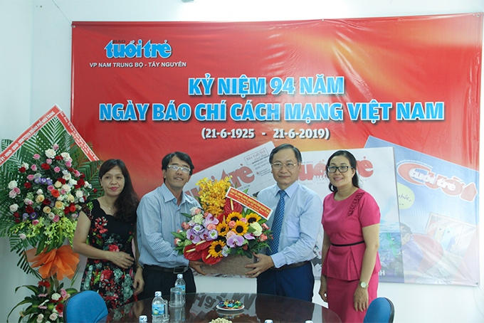 Ông Nguyễn Đắc Tài (thứ 2 từ trái qua) tặng hoa chúc mừng Văn phòng đại diện Báo Tuổi trẻ. 