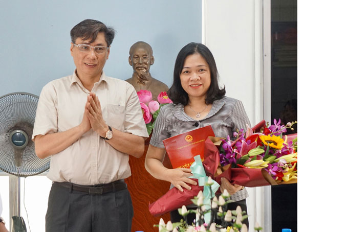Ông Lê Đức Vinh trao quyết định và tặng hoa chúc mừng bà TrầnThu Mai.