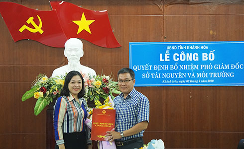 Bà Trần Thu Mai trao quyết định và tặng hoa chúc mừng ông Nguyễn Văn Đồng.