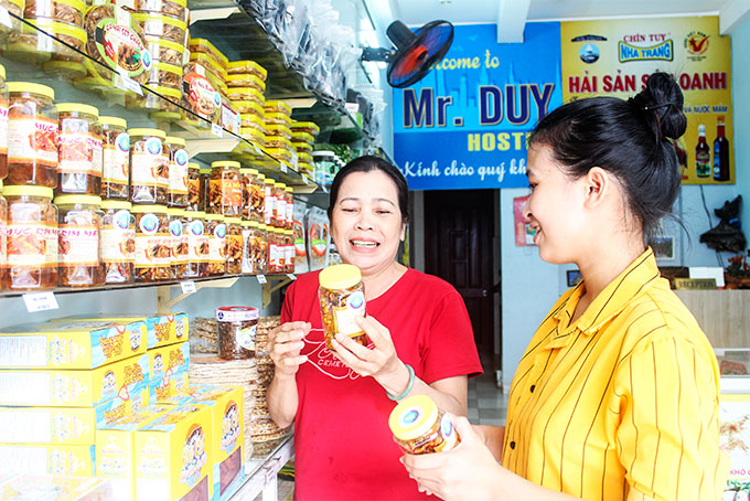Người dân mua sản phẩm được dán tem xác nhận an toàn tại cơ sở hải sản khô Sáu Oanh.     