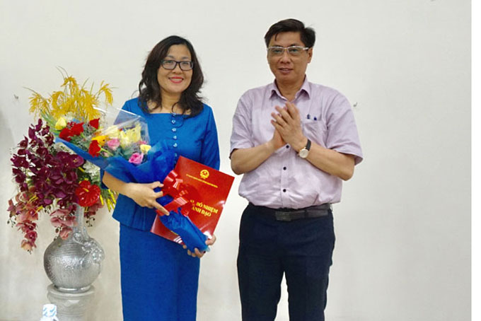Ông Lê Đức Vinh trao quyết định và tặng hoa chúc mừng bà Nguyễn Thị Trung Thu