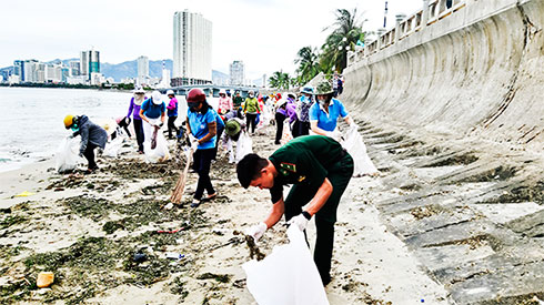 Bộ đội Biên phòng và hội viên phụ nữ thu dọn rác thải tại bãi biển Hòn Chồng.