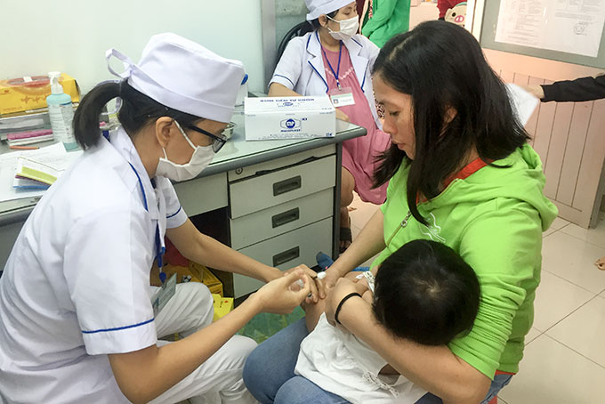 Cán bộ y tế TP. Nha Trang tiêm chủng vắc xin cho trẻ. 