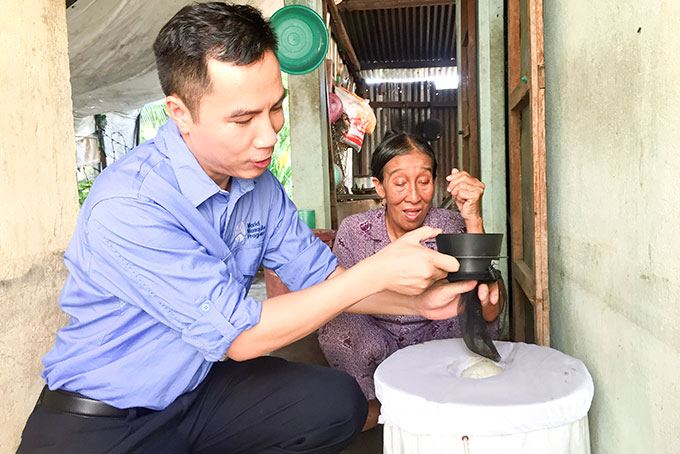 Điều phối viên  của dự án đang  kiểm tra bẫy muỗi  ở nhà dân tại  xã Vĩnh Lương.