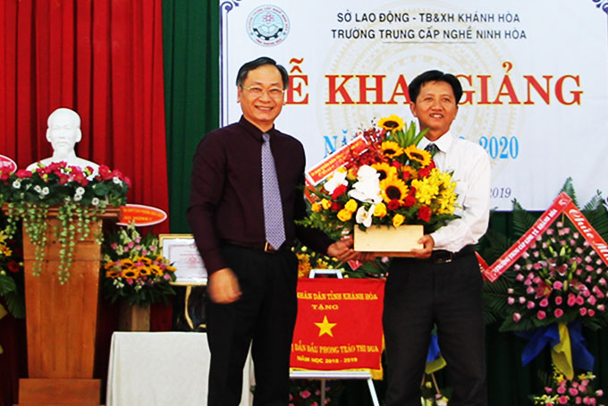 Ông Nguyễn Đắc Tài tặng hoa cho lãnh đạo nhà trường  nhân lễ khai giảng.