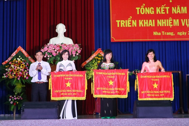 Lãnh đạo Sở Nội vụ trao cờ thi đua của UBND tỉnh Khánh Hòa cho các trường. 