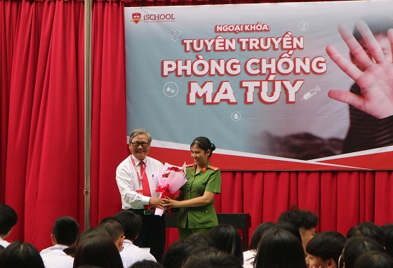 Hiệu trưởng Trường iSchool Nha Trang tặng hoa cho báo cáo viên tuyên truyền về phòng chống ma túy. 