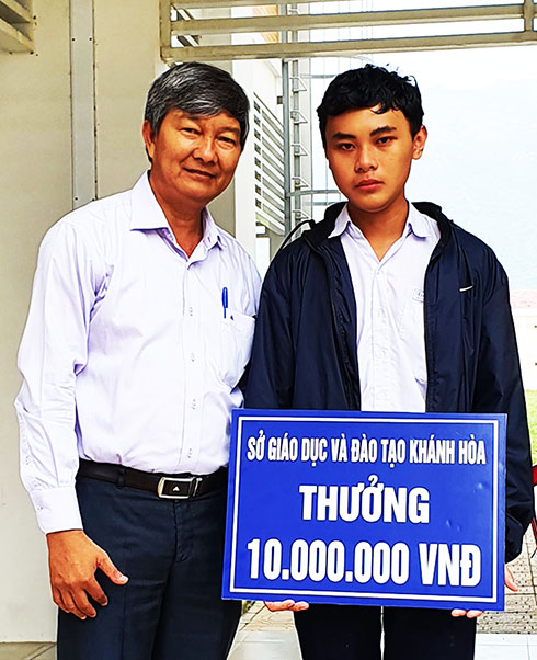 Lãnh đạo Sở Giáo dục và Đào tạo trao phần thưởng cho em Nguyễn Hải Đăng.  