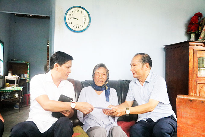 Ông Lê Xuân Hạnh (bìa phải) - Trưởng Ban đại diện Hội Người cao tuổi tỉnh và nhà tài trợ trao quà cho bà Bùi Thị Lý, thị trấn Diên Khánh.
