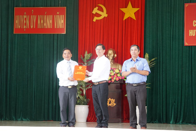 Ông Nguyễn Tấn Tuân (giữa) trao quyết định cho ông Mấu Văn Phi.