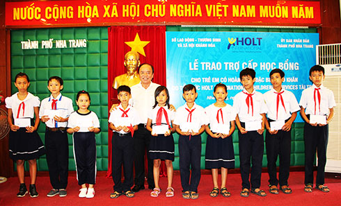 Ông Võ Bình Tân - Phó Giám đốc Sở Lao động - Thương binh và Xã hội  trao học bổng cho các học sinh.