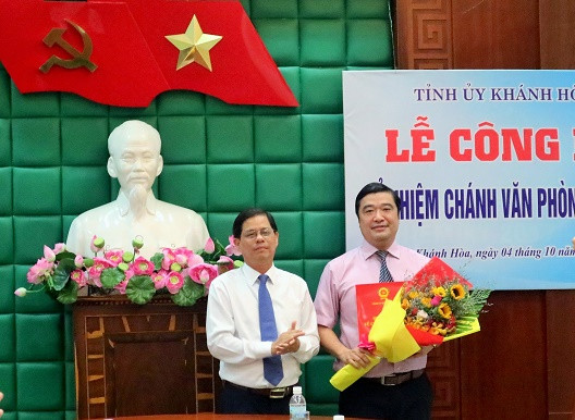 Ông Nguyễn Tấn Tuân trao quyết định và tặng hoa chúc mừng ông Tạ Hồng Quang.  
