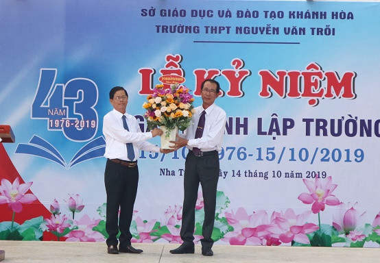 Ông Nguyễn Tấn Tuân tặng hoa chúc mừng nhà trường. 