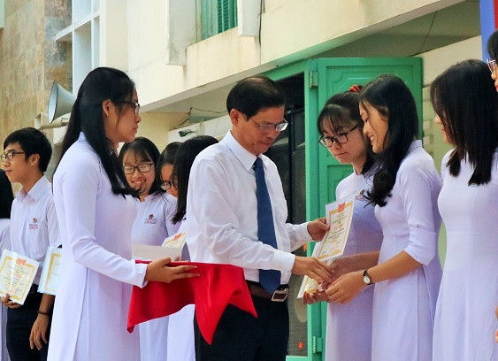 Ông Nguyễn Tấn Tuân rao giấy khen cho các học sinh đạt giải kỳ thi học sinh giỏi THPT năm học 2019-2020.  