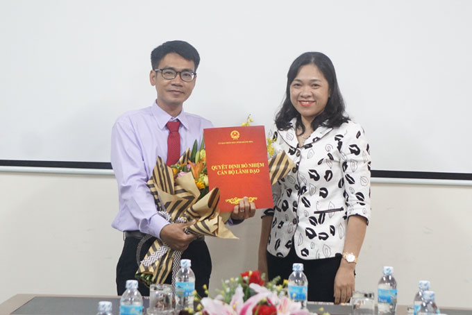 Bà Trần Thu Mai trao quyết định và tặng hoa chúc mừng.
