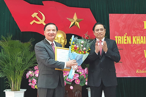 Ông Phạm Minh Chính trao quyết định và tặng hoa chúc mừng ông Nguyễn Khắc Định (bên trái)