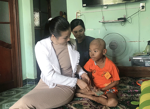 Bà Hoàng Thùy Dương trao tiền hỗ trợ cho bé Minh