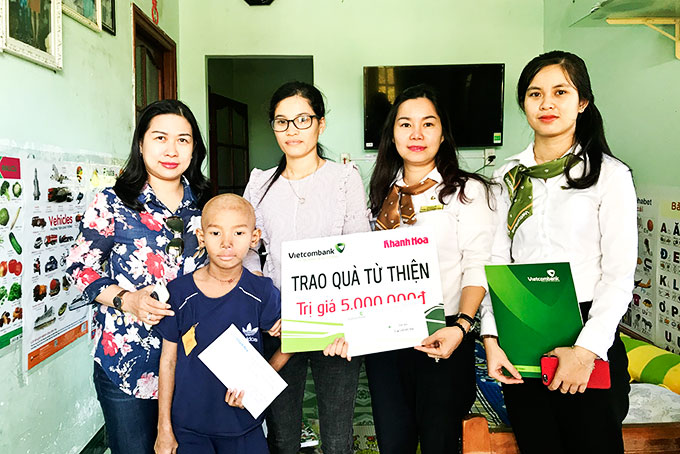 Đại diện Báo Khánh Hòa và Vietcombank Nha Trang  trao tiền ủng hộ cho gia đình bé Lương Nhật Minh. 