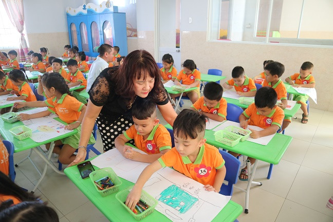 Cô Bùi Thị Thu Hà - Hiệu trưởng nhà trường nhắc nhở các bé ngồi đúng tư thế. 