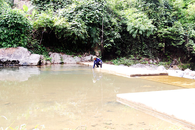 Nhân viên Nhà máy nước Tô Hạp dọn vệ sinh ở đập thu nước thô  tại khu vực suối Tà Lương. 