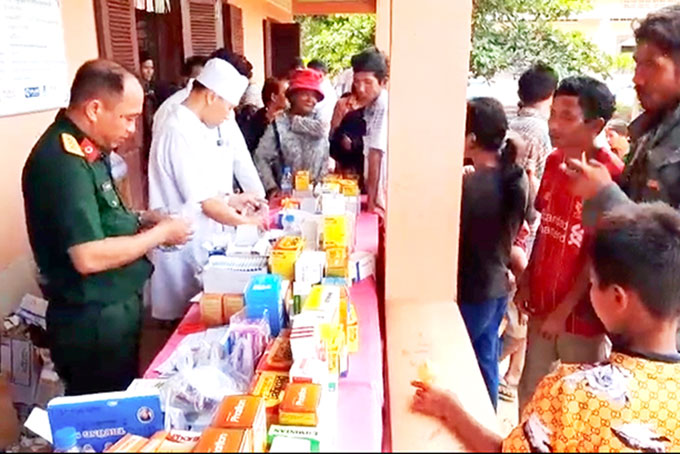 Quân y của đoàn công tác cấp thuốc chữa bệnh  cho người dân Campuchia.