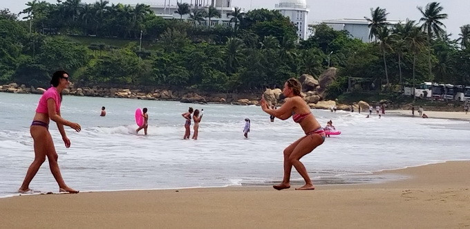 Nhiều du khách nước ngoài vẫn kéo xuống biển tắm, chụp ảnh dù sóng lớn