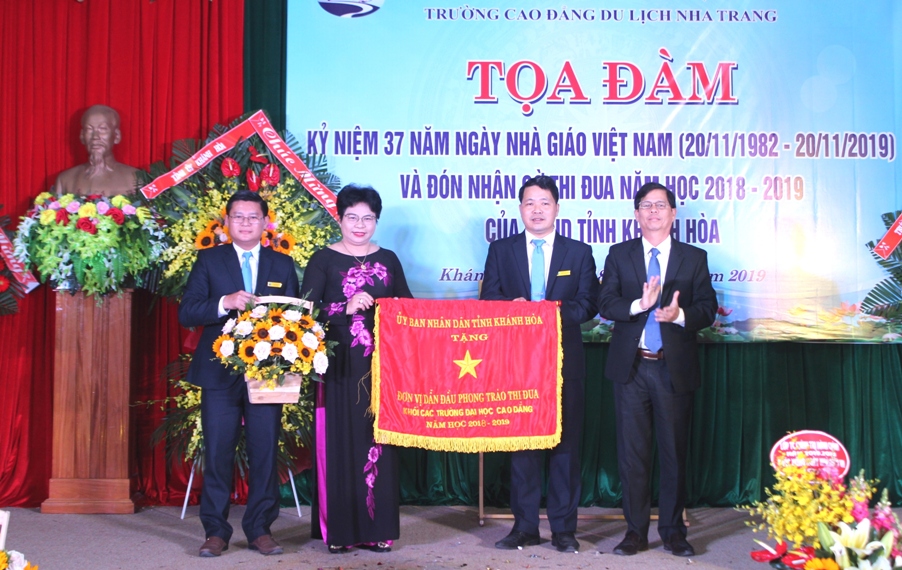 Ông Nguyễn Tấn Tuân trao cờ thi đua xuất sắc cho nhà trường.