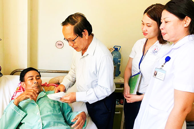 Ông Trương Tấn Minh - Chủ tịch Hội Bảo trợ người tàn tật, trẻ em mồ côi  và bệnh nhân nghèo trao tiền cho bệnh nhân.