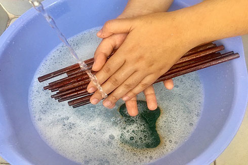 Chà xát đũa với nhau khi rửa có thể khiến vi khuẩn dễ xâm nhập vào bên trong đũa. Ảnh: Cẩm Anh