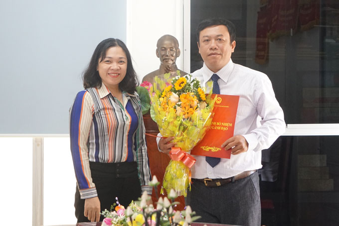 Bà Trần Thu Mai trao quyết định và tặng hoa chúc mừng.