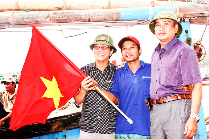 Đại diện Liên đoàn Lao động tỉnh trao cờ Tổ quốc  cho các chủ tàu thuộc các nghiệp đoàn nghề cá.