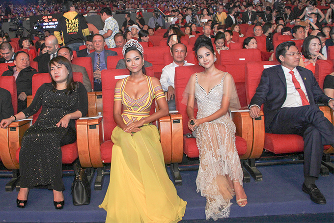 Hoa hậu H'Hen Niê (trang phục màu vàng) ngồi dưới hàng ghế khán giả để theo dõi cuộc thi. 