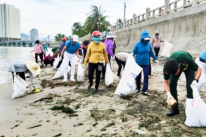 Phụ nữ Nha Trang phối hợp với bộ đội biên phòng thu gom rác tấp vào bờ biển Nha Trang.