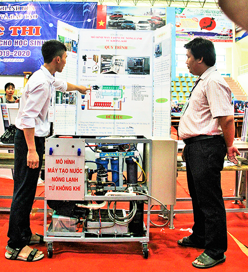 Em Nguyễn Quốc Việt và thầy giáo hướng dẫn bên cạnh dự án Mô hình máy tạo nước nóng lạnh từ không khí. 