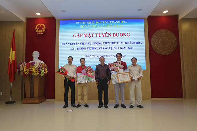 Ông Trần Quang Thưởng tặng thưởng cho 2 HLV đội tuyển điền kinh tỉnh Lê Đình Hải (trái), Ngô Văn Phúc (phải) vì có công trong việc tìm kiếm đào tạo VĐV đạt thành tích cao.