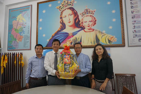 Ông Huỳnh Mộng Giang (bìa trái) trao quà cho Linh mục Trần Huy Hoàng - Quản xứ Bắc Thành, NhaTrang.