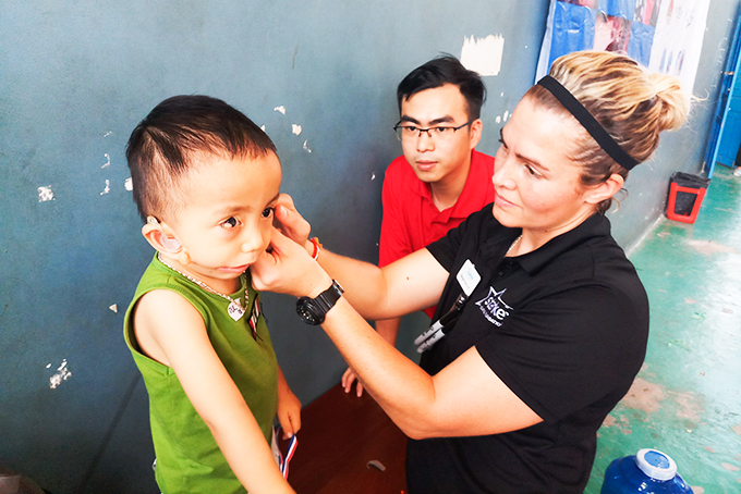 Kỹ thuật viên của chương trình lắp máy trợ thính cho một em nhỏ tại Khánh Hòa năm 2018. 