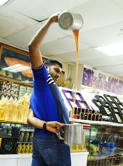 Nhân viên một nhà hàng đang biểu diễn  làm món chè sữa đặc trưng của người Ấn Độ.