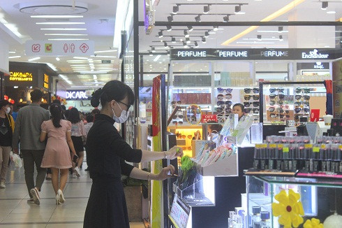 Nhân viên bán hàng của một shop thời trang tại siêu thị cũng đeo khẩu trang kín mít .