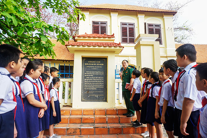 Ông Trịnh Đại Mỹ nói chuyện với các học sinh Trường Tiểu học số 3 Ninh Hiệp về di tích lịch sử Trường Pháp - Việt Ninh Hòa.