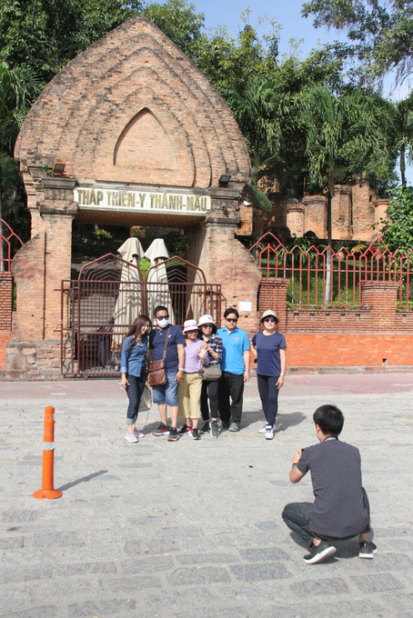 Không được vào tham quan, nhóm du khách chụp ảnh lưu niệm trước cổng chính của Khu Di tích Tháp Bà Ponagar