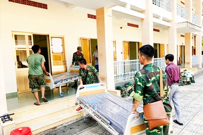 Cán bộ, chiến sĩ Trung đoàn Gia Định (Bộ Tư lệnh TP. Hồ Chí Minh) đưa giường bệnh vào khu vực Bệnh viện dã chiến. Ảnh: TTXVN  