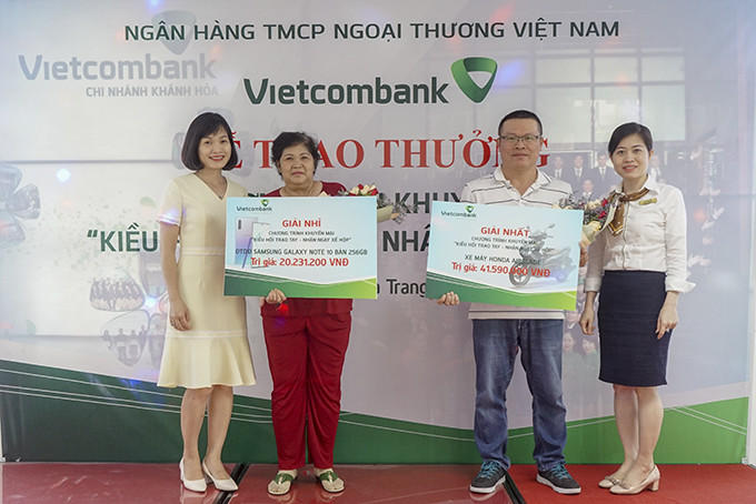 Bà Võ Thị Thu Hương (bìa trái) trao thưởng cho các khách hàng. 