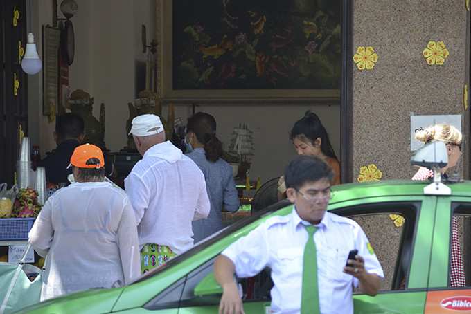 Người lái lái Taxi, du khách và nhân viên bán hàng không đeo khẩu trang theo quy định. Ảnh chụp tại đường Trần Phú