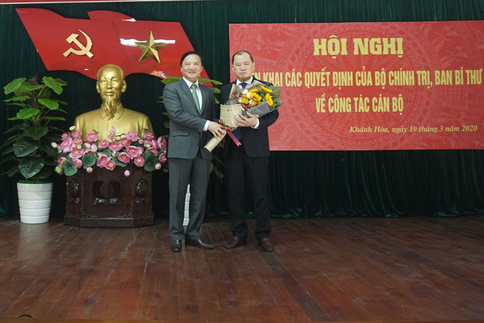 Ông Nguyễn Khắc Định trao quyết định và tặng hoa chúc mừng ông Nguyễn Anh Tuấn. 