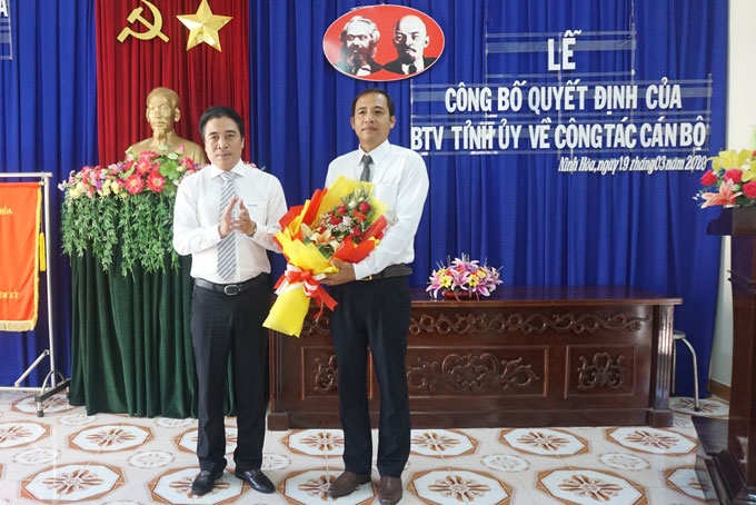 Ông Nguyễn Khắc Toàn trao quyết định và tặng hoa chúc mừng ông Trần Văn Phải.