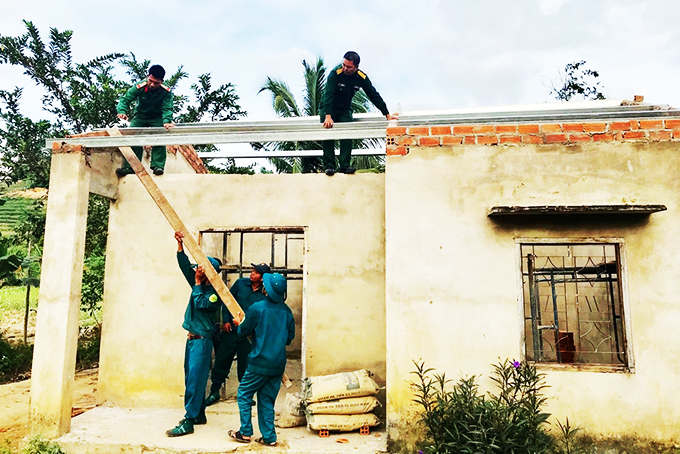Lực lượng dân quân tự vệ huyện Khánh Sơn  tham gia sửa chữa nhà giúp dân.