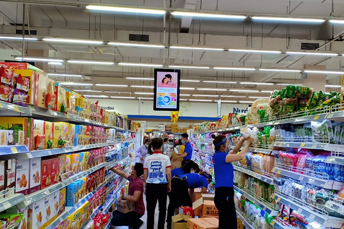 Nhân viên siêu thị bổ sung thêm hàng để đáp ứng nhu cầu mua sắm của người dân.