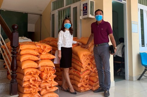 Lãnh đạo Công ty Cổ phần Đông Dương Nha Trang (bìa phải) bàn giao 1,6 tấn gạo cho UBND phường Vĩnh Hòa.